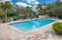 Inviting outdoor pool area with palm trees and lounge seating, perfect for relaxation and leisure.