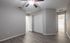 Bright and spacious bedroom with modern laminate flooring, featuring a sleek ceiling fan and ample closet space.