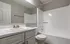 Bright and modern bathroom featuring a sleek white bathtub, elegant sink vanity, and large mirror, offering a clean and inviting space.