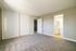 Spacious bedroom with plush carpet, neutral walls, ample closet space, and an en-suite bathroom.