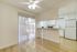 Bright dining space with sliding glass door and open kitchen featuring modern appliances.