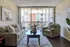 Charming living room with cozy seating, elegant decor, and sliding glass doors leading to a bright balcony.