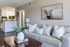 Charming living room with elegant decor, cozy textured sofa, and a stylish open kitchen in a bright, inviting apartment.