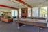 Inviting recreational room featuring billiard tables, cozy seating, a modern fireplace, and chic chandeliers, perfect for entertaining.