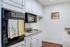 Charming kitchen with sleek black appliances, white cabinetry, and polished countertops for a modern touch.