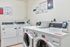 Modern communal laundry room equipped with high-efficiency washers and dryers, offering convenience and efficiency for residents.