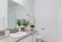 Elegant bathroom with stylish granite countertop, large mirror, and modern fixtures, creating a bright and inviting space.