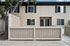 Charming two-story townhouse with a cozy fenced patio, large windows, and stylish shutters, perfect for modern living.