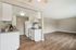 Bright and airy open-plan living area with a modern kitchen, featuring stylish wooden flooring and sleek white cabinetry.