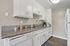 Modern kitchen with sleek granite countertops, stainless steel sink, and white cabinetry, offering a stylish cooking space.