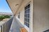 Stylish outdoor apartment hallway with welcoming entrance, featuring a modern aesthetic and lush courtyard views.
