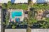 Stunning aerial view of a luxurious apartment complex showcasing a large swimming pool, lush greenery, and inviting communal spaces.