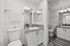 Modern bathroom with sleek granite countertops, stylish dual mirrors, and elegant lighting. Bright space featuring a fresh white color palette and cozy amenities, creating a welcoming atmosphere.