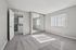 Bright bedroom with plush carpet, large mirrored closet, and inviting natural light through vertical blinds.