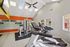 Bright and modern fitness center featuring state-of-the-art treadmills, versatile exercise machines, and motivational decor with ample natural light from skylights.