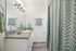 Elegant bathroom featuring sleek granite countertops, modern fixtures, and stylish green accents.