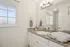 Bright bathroom with elegant granite countertop, stylish lighting, and inviting window view.