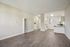 Bright open-concept living area with sleek flooring and a modern kitchen, perfect for stylish urban living.