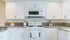 Bright and modern kitchen featuring sleek white cabinetry, granite countertops, and state-of-the-art appliances.