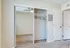 Inviting apartment bedroom featuring spacious mirrored closet doors, plush carpet, and modern ceiling fan for comfort and style.