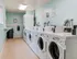 Bright and welcoming laundry room with multiple state-of-the-art washers and dryers, featuring an efficient layout perfect for busy apartment living.