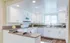 Bright and modern kitchen with sleek white cabinetry, granite countertops, and stainless steel appliances, perfect for culinary enthusiasts.