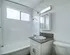 Bright and modern bathroom featuring sleek fixtures, granite countertop, and ample natural light through a large window.