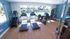 Bright, modern fitness center with large windows, featuring treadmills, strength machines, and a scenic pool view.