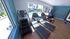 Modern fitness center with state-of-the-art exercise equipment, large windows overlooking a serene pool area, and stylish flooring.