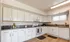 Bright and modern kitchen featuring sleek white cabinetry, elegant granite countertops, and high-end appliances, perfect for culinary enthusiasts.