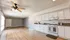 Bright open-concept kitchen and living area with elegant wood flooring and modern white cabinetry.
