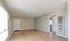 Bright, open-concept living room featuring elegant hardwood floors, neutral walls, and abundant natural light from large window blinds.