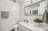 Elegant bathroom featuring a sleek marble countertop, modern fixtures, and a stylish mirror, perfect for a spa-like retreat.