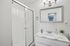 Elegant bathroom featuring a sleek glass-enclosed shower and stylish marble countertop with modern fixtures.