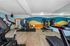 Modern fitness center featuring state-of-the-art exercise equipment, dynamic colorful wall art, and expansive mirrors for a vibrant workout experience.