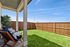 Charming backyard with lush green lawn, cozy seating area, and privacy fencing, perfect for outdoor relaxation.