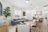 Modern open-concept living room with stylish decor, large window, and elegant dining area adjacent to a sleek kitchen.