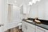 Elegant bathroom with sleek black countertop, modern fixtures, and stylish cabinetry, offering a spa-like ambiance.