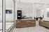 Modern apartment lobby featuring sleek marble countertops, a stylish coffee station, and contemporary decor with plush seating.
