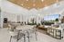 Elegant communal area with modern seating, sleek wooden ceiling, and abundant natural light from large windows.