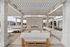 Elegant outdoor lounge area with modern white pergola, stylish seating, and a cozy fireplace beside a refreshing pool, perfect for relaxation and entertaining.