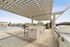 Luxurious outdoor area featuring a modern pergola, sleek stone countertops, and a sparkling pool with private cabanas.