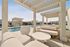 Luxurious outdoor patio with elegant seating and stylish pergolas overlooking a shimmering pool, perfect for relaxation and entertainment.