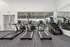 Modern fitness center showcasing state-of-the-art treadmills and step machines, overlooking a serene outdoor seating area.