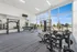 Modern gym with state-of-the-art fitness equipment, floor-to-ceiling windows, and serene outdoor views.