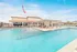 Inviting outdoor pool area with modern loungers and a shaded seating area, perfect for relaxation and enjoyment.