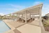 Inviting outdoor lounge area next to a sparkling pool, featuring comfortable seating under a stylish pergola.