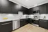 Modern kitchen with dark cabinets and stainless steel appliances in Denton TX rental home near Rayzor Ranch