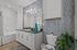 Contemporary bathroom with elegant gray mosaic tiles, sleek white cabinetry, and modern fixtures, creating a serene spa-like atmosphere.