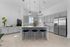 Modern community kitchen with sleek cabinetry, stainless steel appliances, and a chic island with bar seating. Complimentary coffee bar